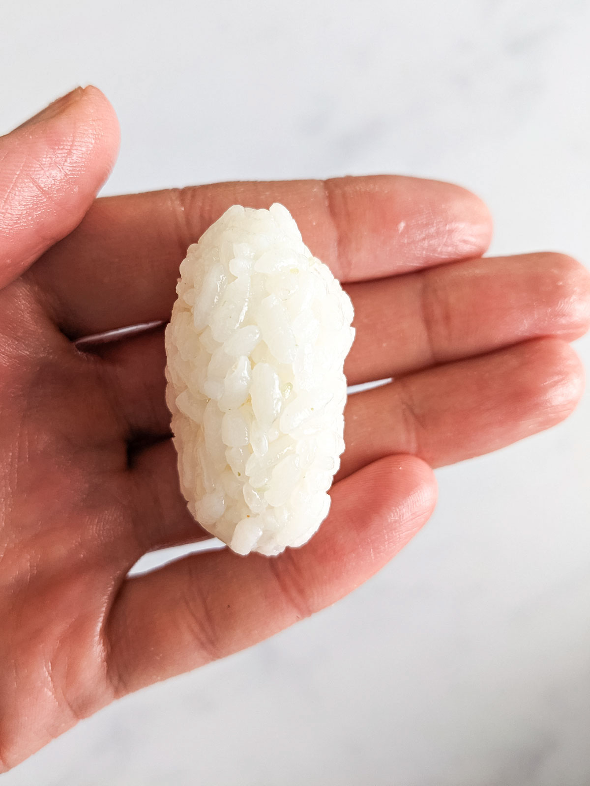 A small oval rice ball of sushi rice.