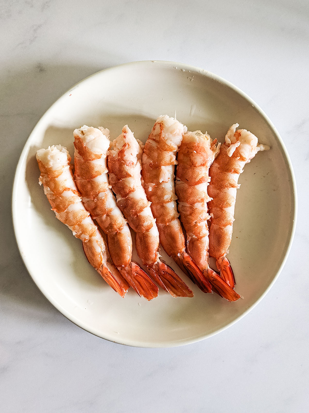 The cooked shrimp after peeling off the shells leaving the tail intact.