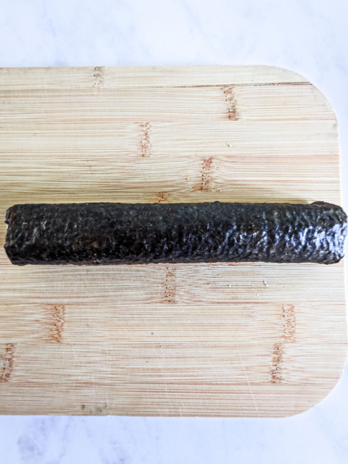 The completed roll on a wooden board on a white background.