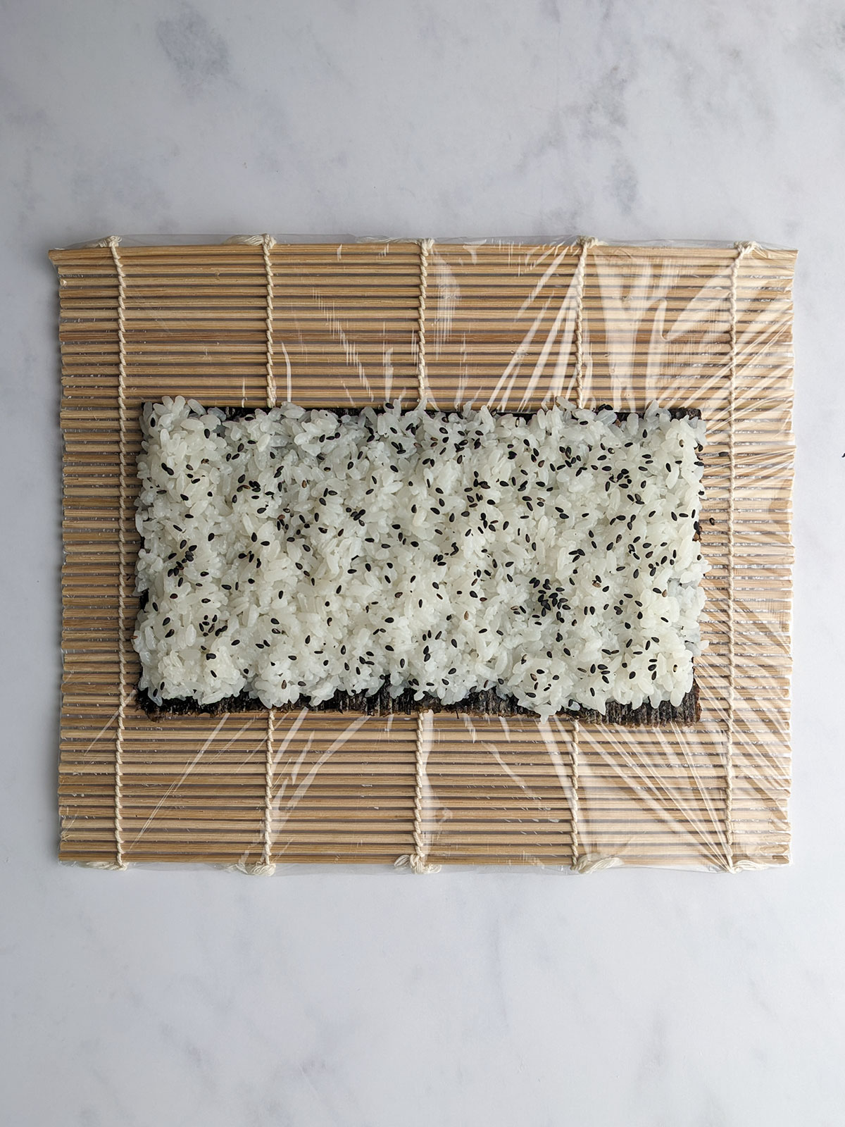 Nori topped with rice and sesame seeds.